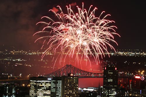 Fireworks Display over City Buildings during Night Time
