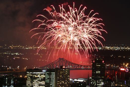 Vibrant fireworks exploding over city skyline at night, showcasing a festive celebration.