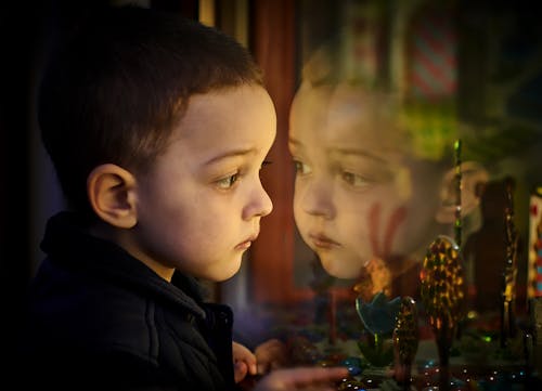 Free A Boy Looking Outside the Window Stock Photo