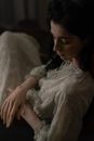 Woman in Gray Sweater Sitting on White Textile
