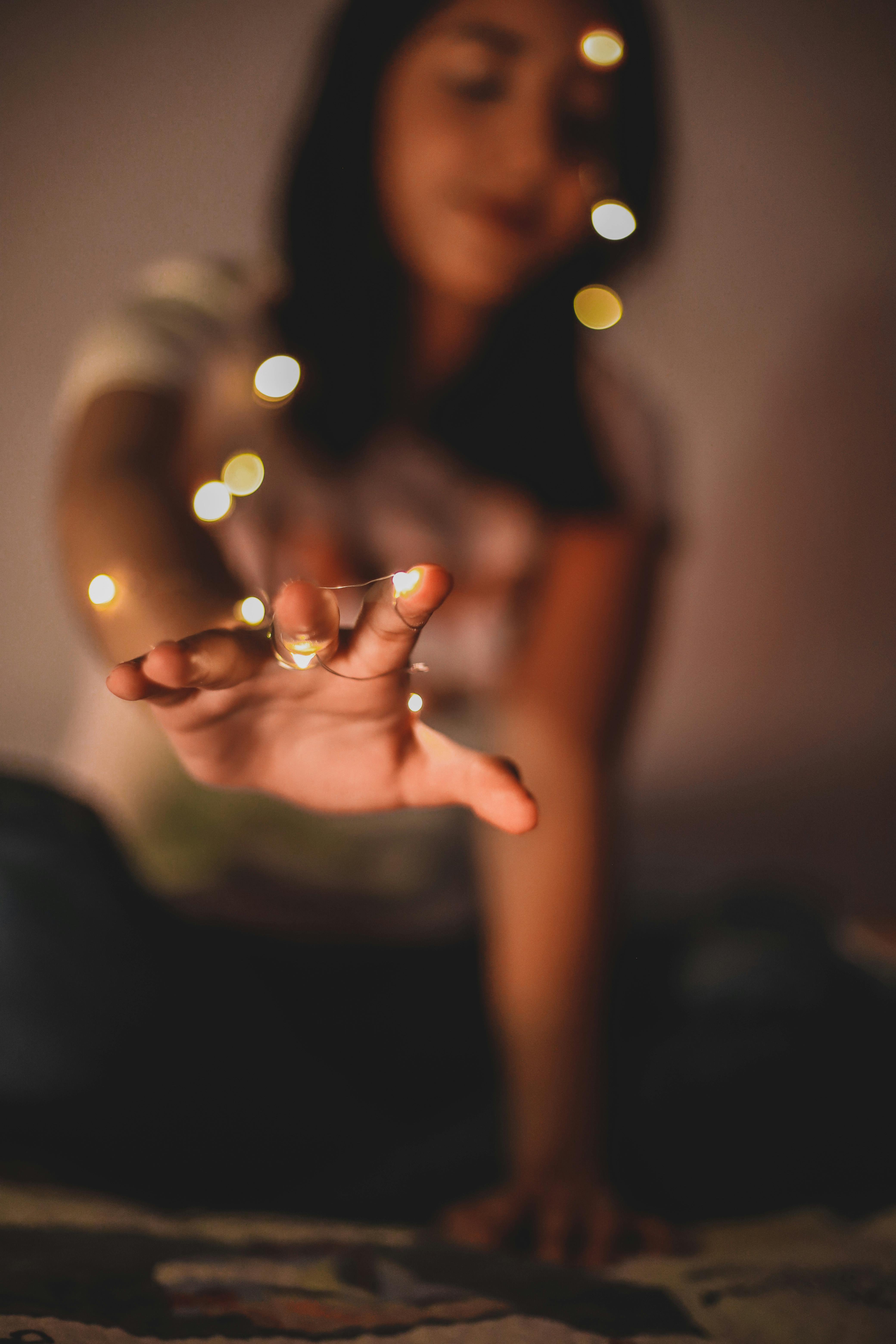 A Woman in White Long Sleeves Holding Fairy Lights · Free Stock Photo