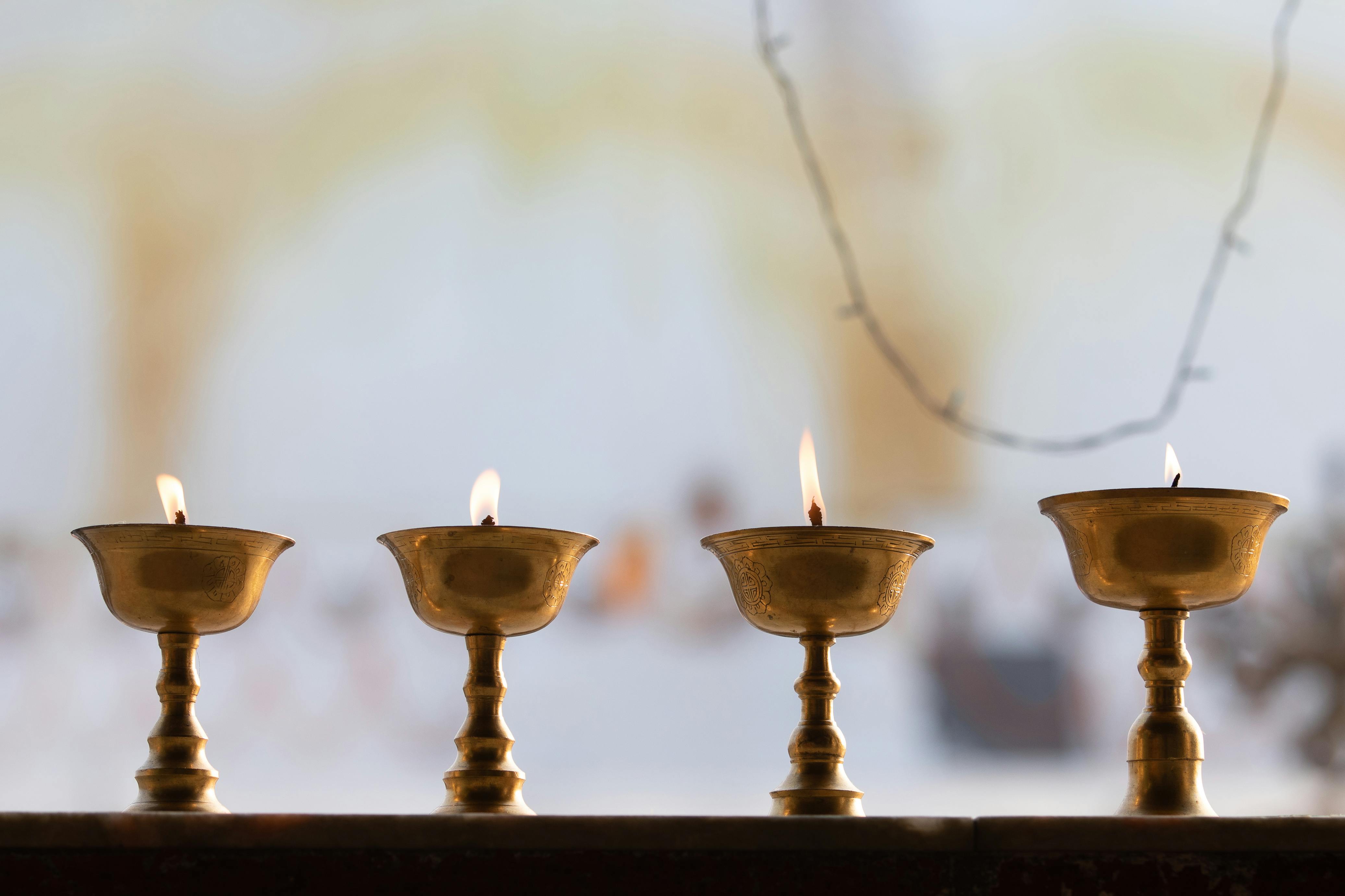 Brass oil lamps burning in a temple in Kathmandu, providing a serene ambiance with soft candlelight.