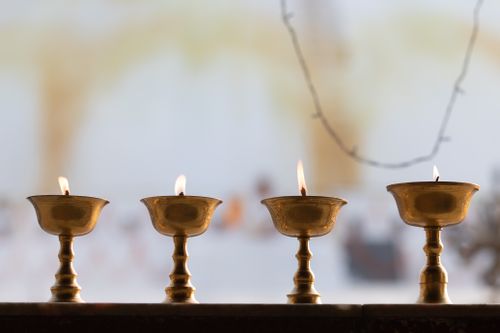 Free Brass oil lamps burning in a temple in Kathmandu, providing a serene ambiance with soft candlelight. Stock Photo