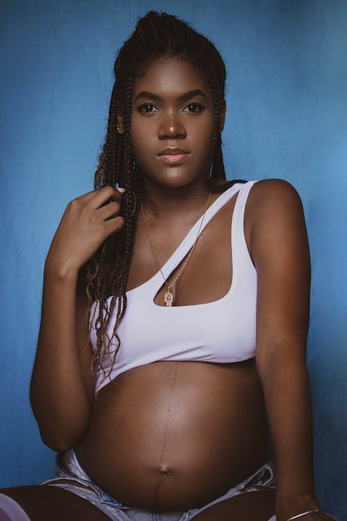 Free Portrait of Pregnant Woman in White Sports Bra with Braided Hair Stock Photo