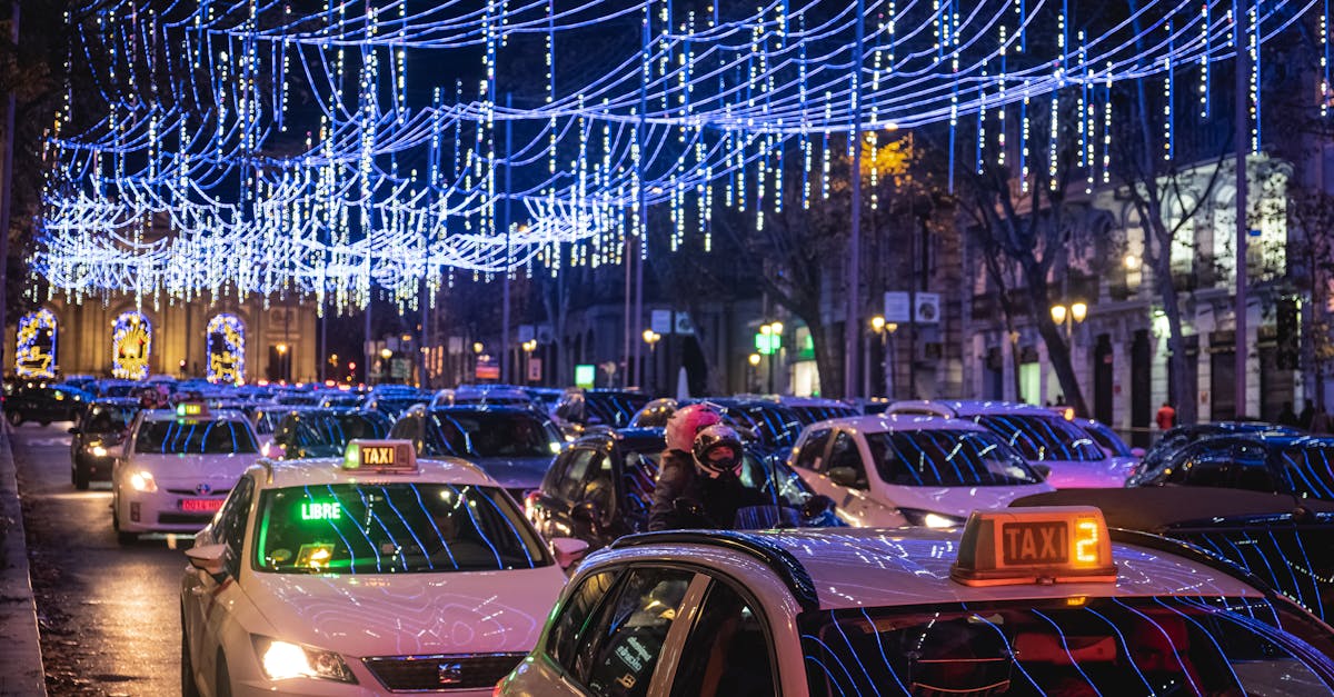 Vibrant city street in Madrid featuring taxis under festive Christmas lights at night.
