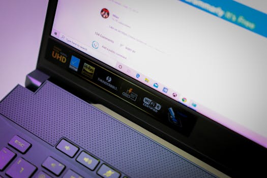 Close-up of an open laptop focusing on screen and keyboard with various icons and text.