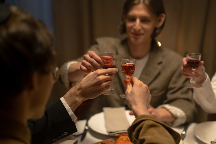 Group Of People Making A Toast With Red Wine