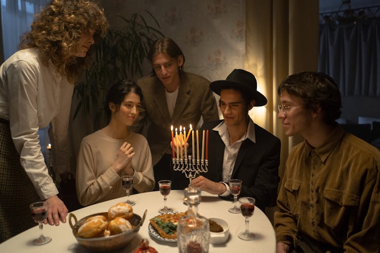 Man Lighting Up Candles In Menorah