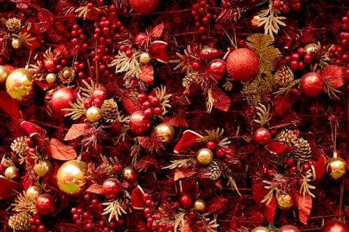 Full frame decorated Christmas tree with sparkling red and golden baubles cones and ribbons