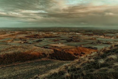 Free A beautiful aerial landscape photograph of the Scottish countryside with fields and hills under a cloudy sky. Stock Photo