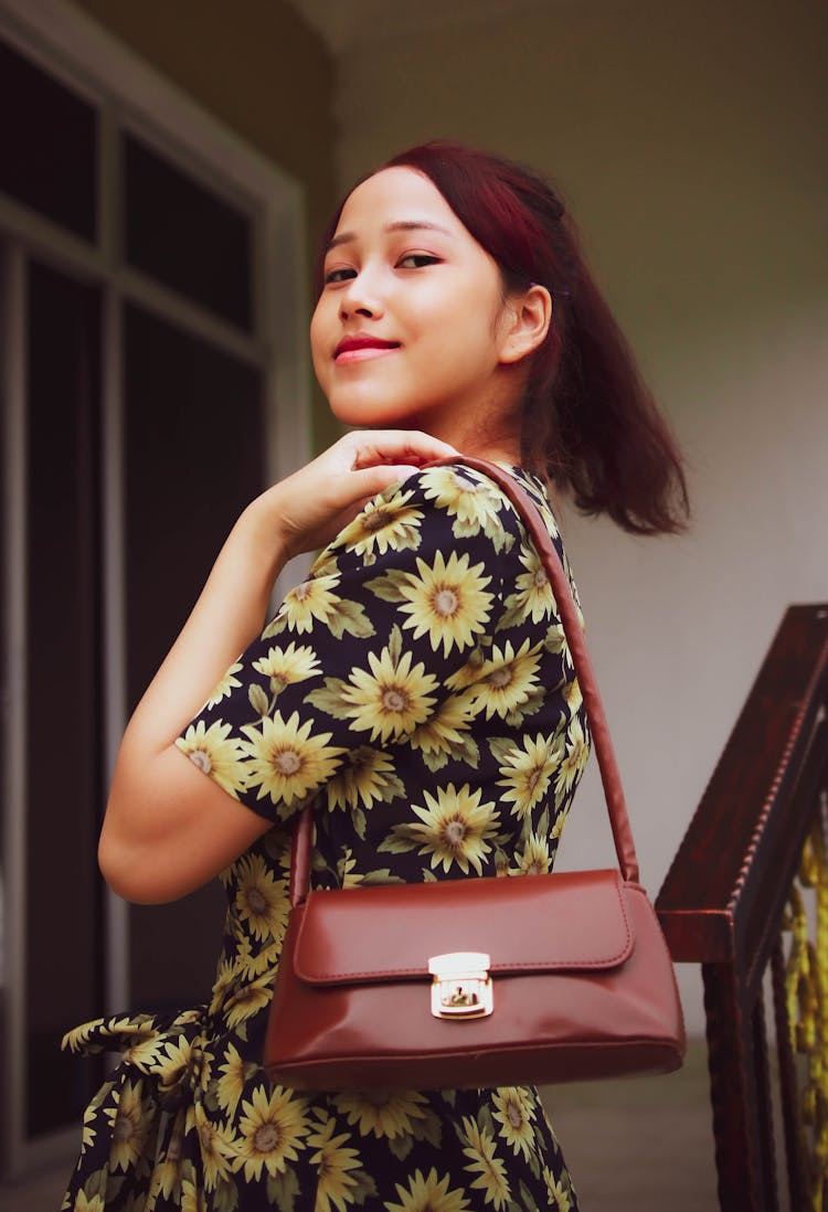 Woman In Sunflower Dress Wearing A Brown Shoulder Bag 