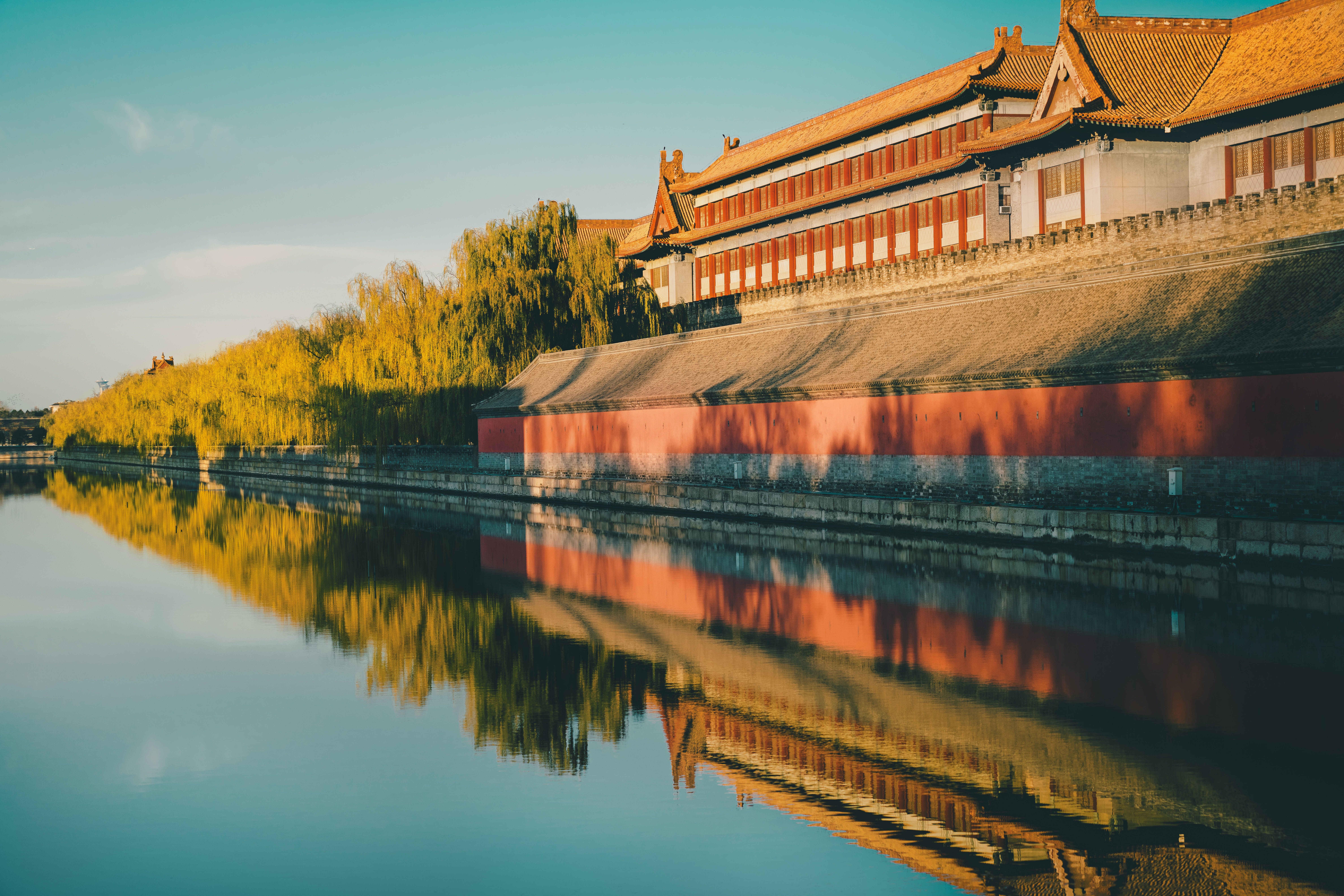 Golden sunset reflects on the historic Forbidden City walls in Beijing, China.