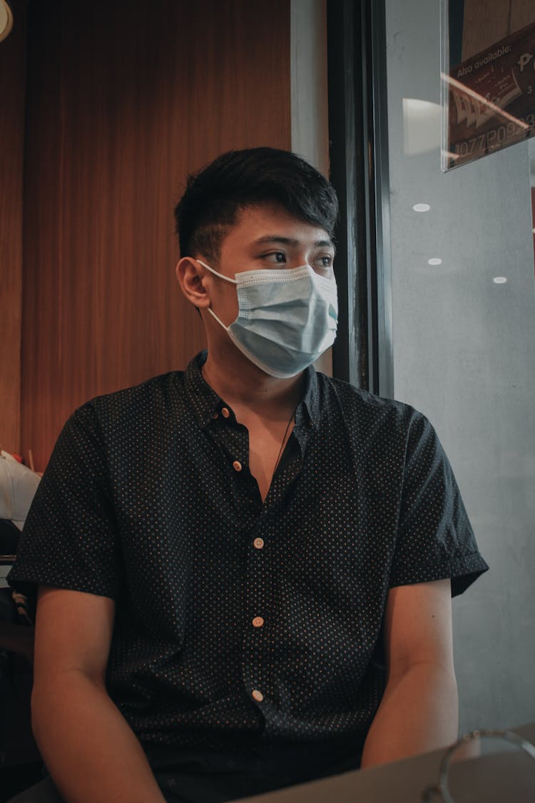 Man Wearing Short Sleeve Polo Sitting Near The Window