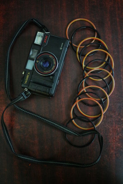 Darmowe zdjęcie z galerii z czarny aparat, drewniana powierzchnia, obiektyw