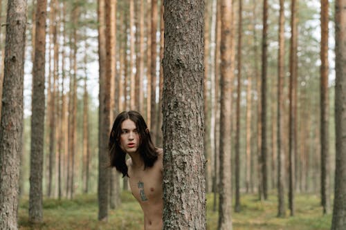 Bezpłatne Topless Kobieta Stojąca Obok Brązowego Drzewa Zdjęcie z galerii