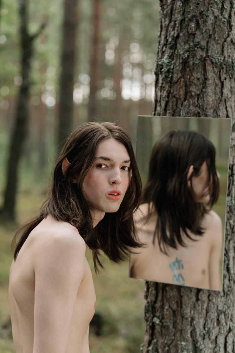 Topless Person Standing Near The Hanging Mirror 