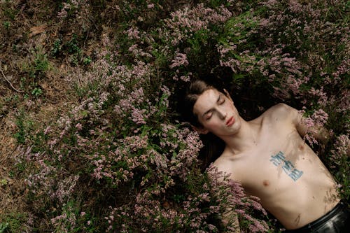 Topless Person Lying on Flower Field