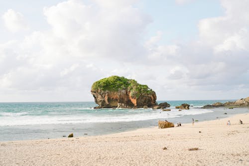 Natural Rock Formation Near a Beach under White Clouds