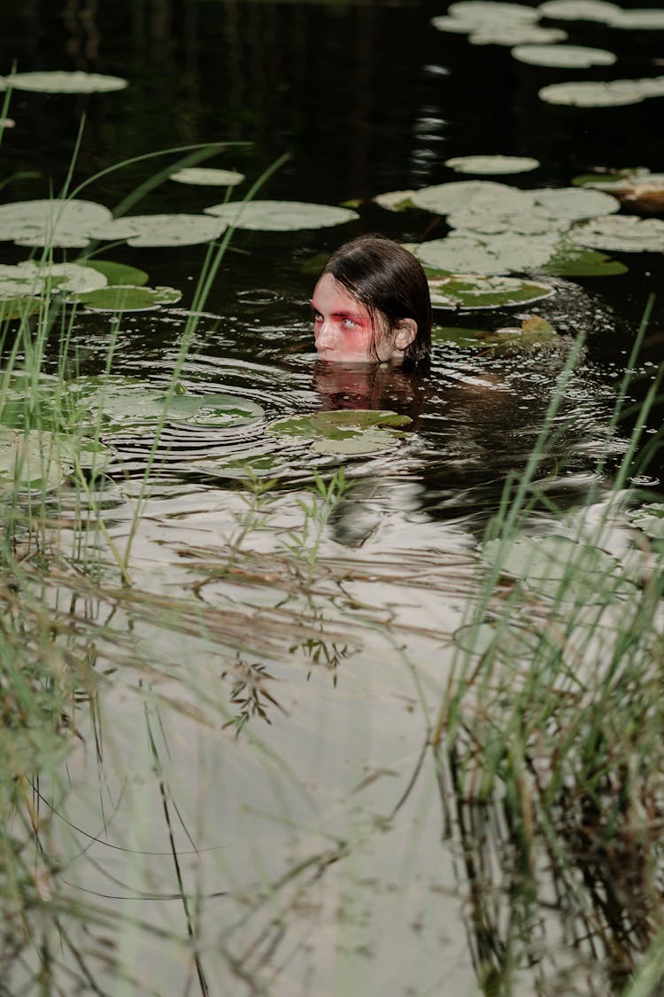 A Man Swimming In The Lake While Looking Afar