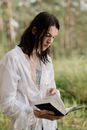 Woman in White Long Sleeve Shirt Reading Book
