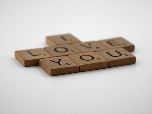 Free Scrabble Tiles on a White Surface Stock Photo