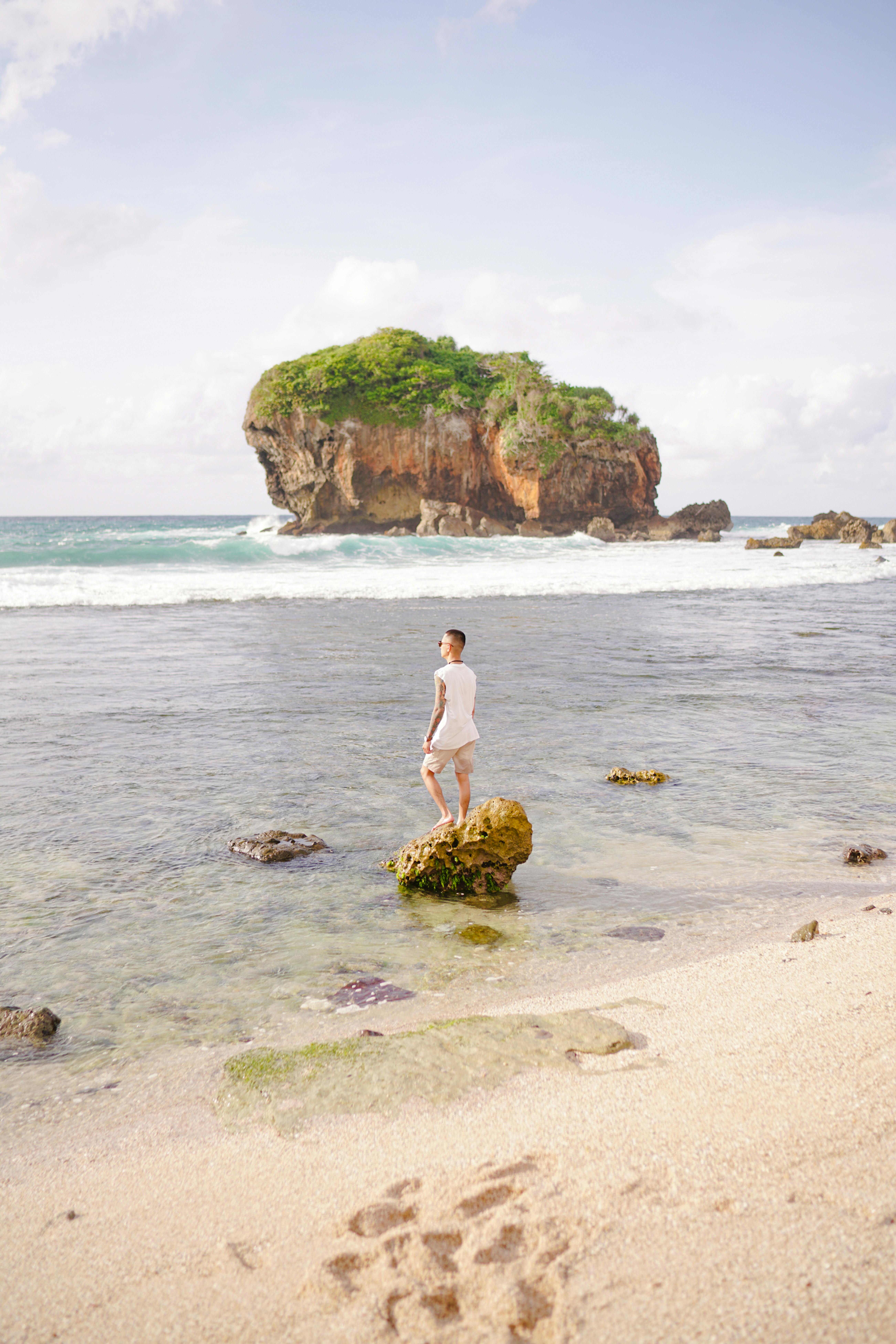 A man enjoying the scenic seaside view in Jogja, Indonesia, under bright summer skies.