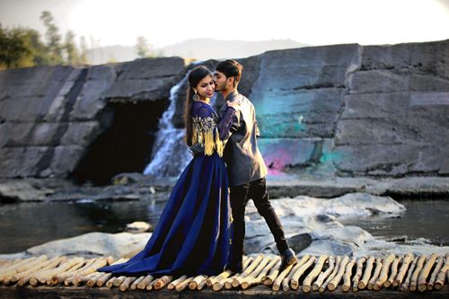 Free A young South Asian couple embraces near a beautiful waterfall in Surat, India. Stock Photo