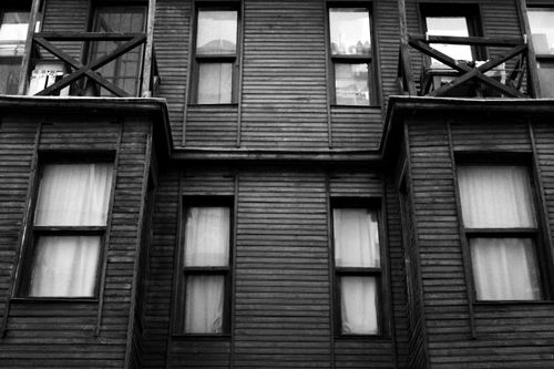 Free Grayscale photo of an urban building facade with wooden design and glass windows. Stock Photo