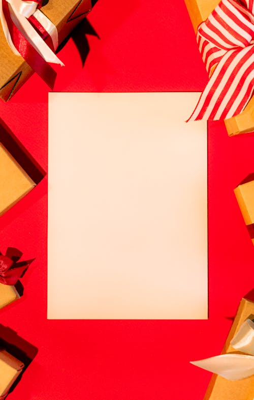 A Blank White Paper Surrounded by Gift Boxes