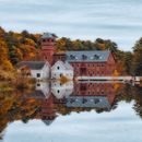 Aged residential cottage reflecting in water