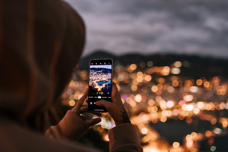 Crop Unrecognizable Person Taking Photo Of Night City On Smartphone