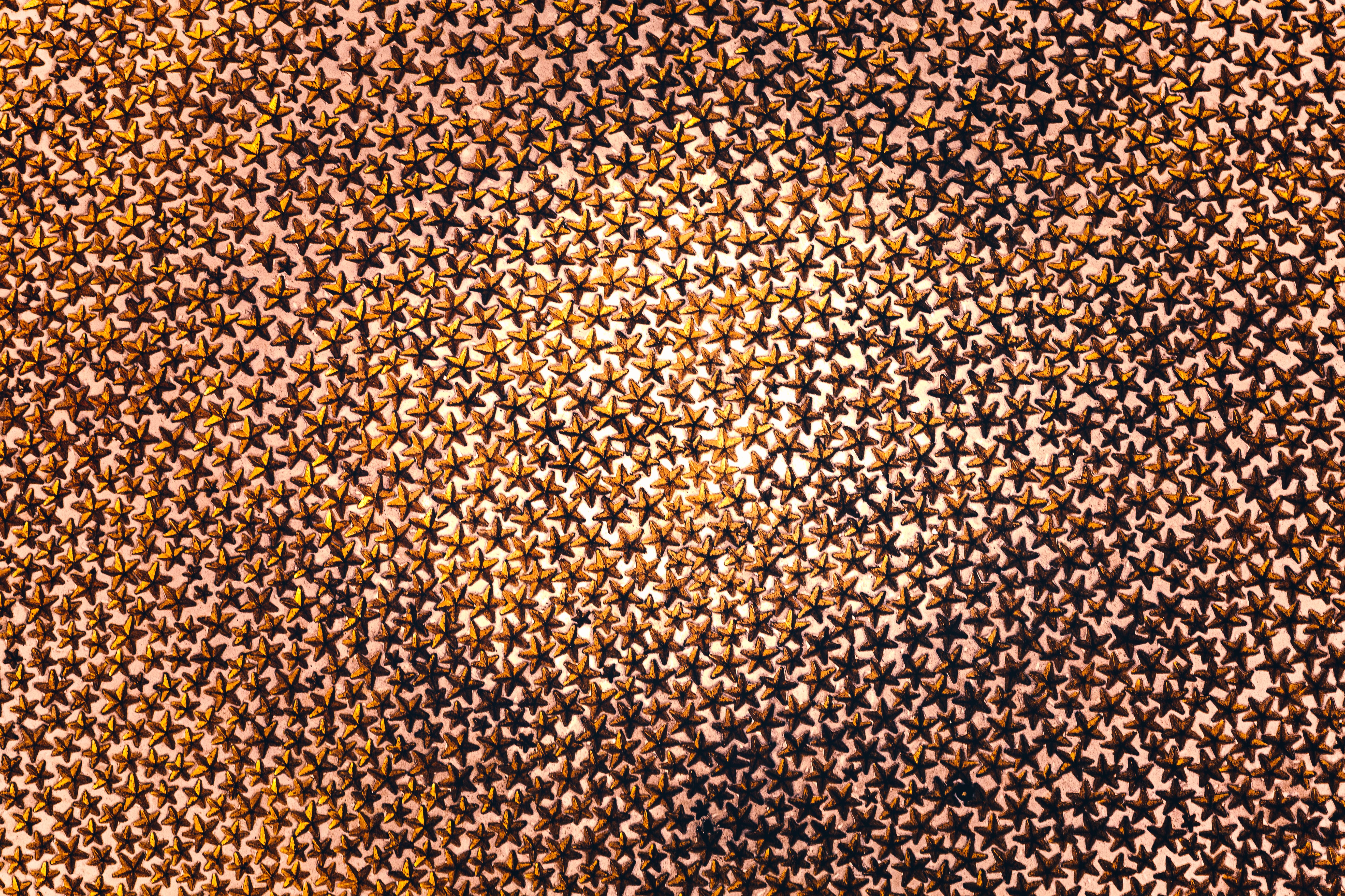 A captivating abstract pattern featuring an abundance of golden star designs creating a mesmerizing visual effect.