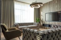 Interior of modern room with soft furniture near TV set and huge window