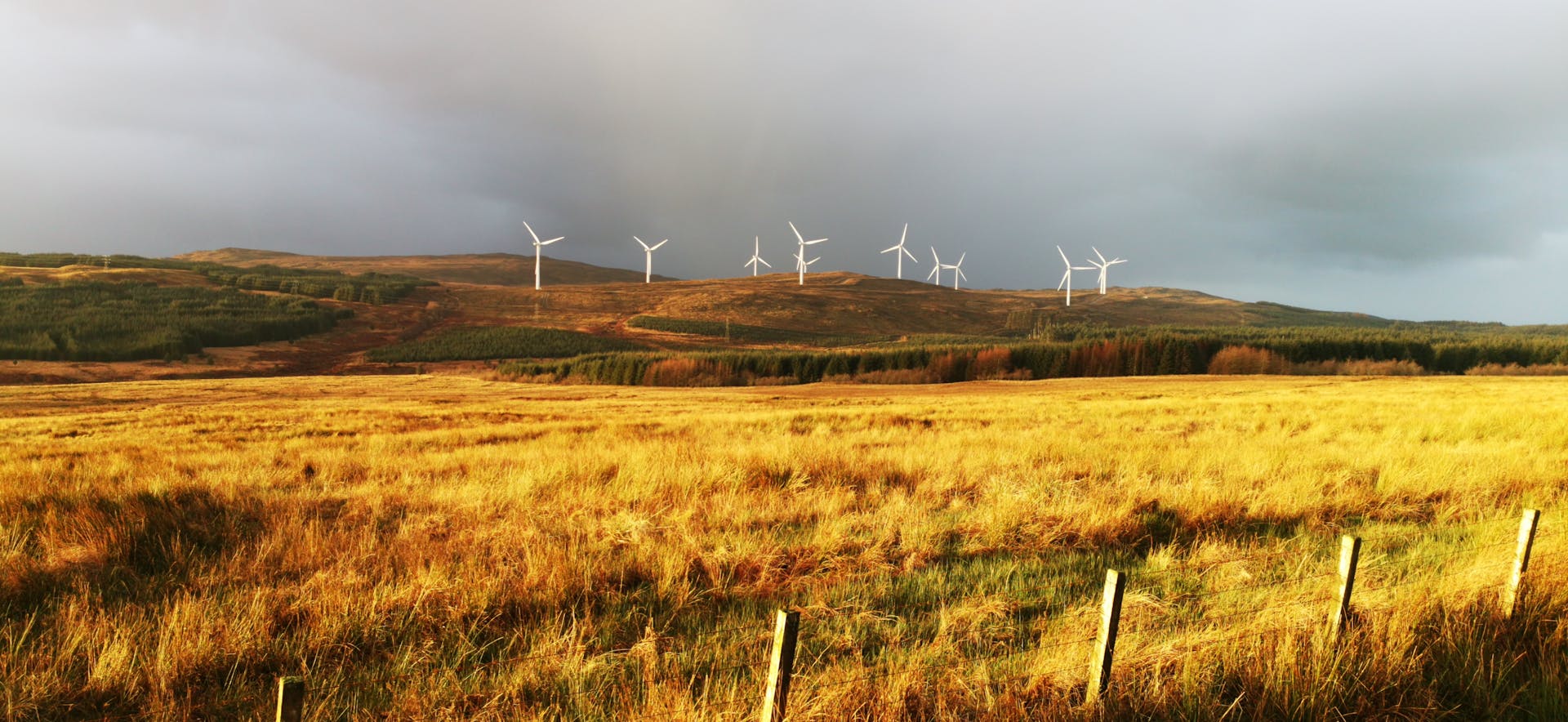 Wind turbines in Claonaig, Scotland, showcasing renewable energy amidst lush fields.