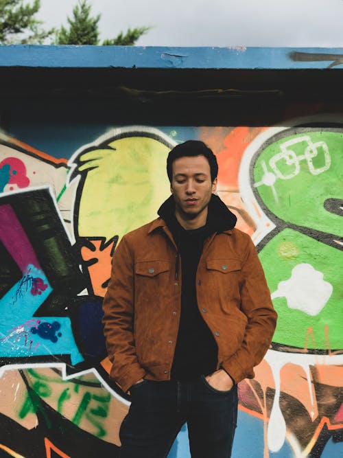 Free Man in a Brown Jacket Near a in Brown Jacket Standing Near a Wall with Graffiti Stock Photo