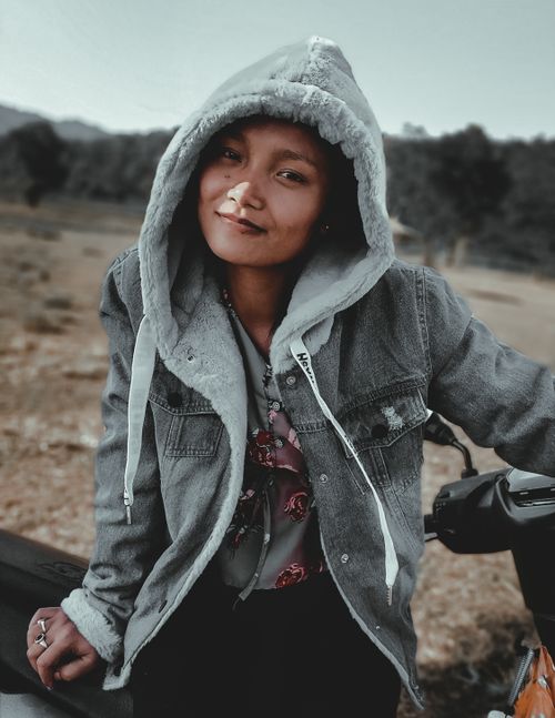 Free Stylish woman in denim hoodie posing outdoors, exuding confidence and relaxed vibes. Stock Photo