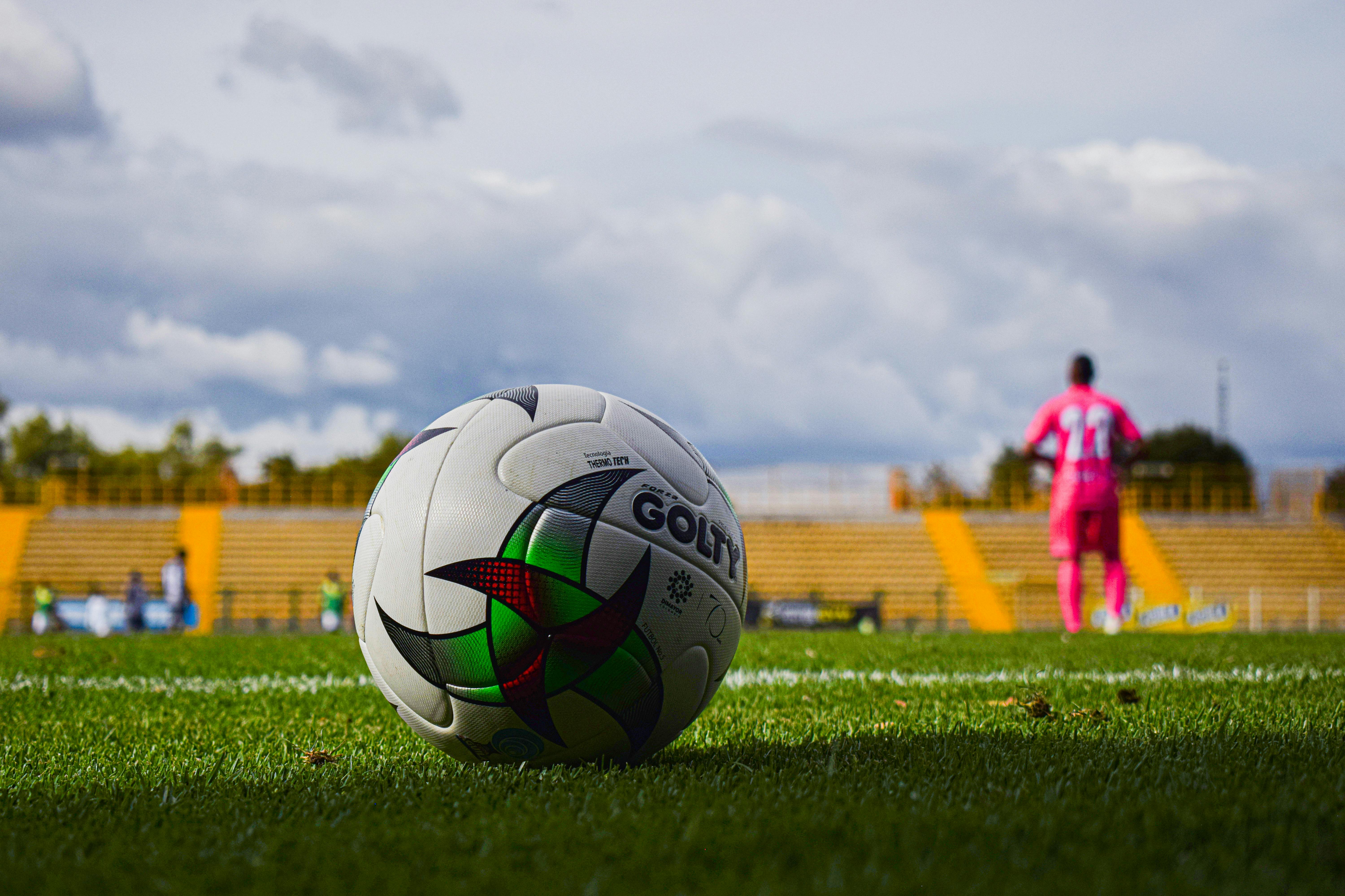 close up photo of a football on a green grass field