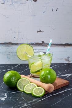Chilled lime drink with fresh slices on a marble table, perfect for summer refreshment.