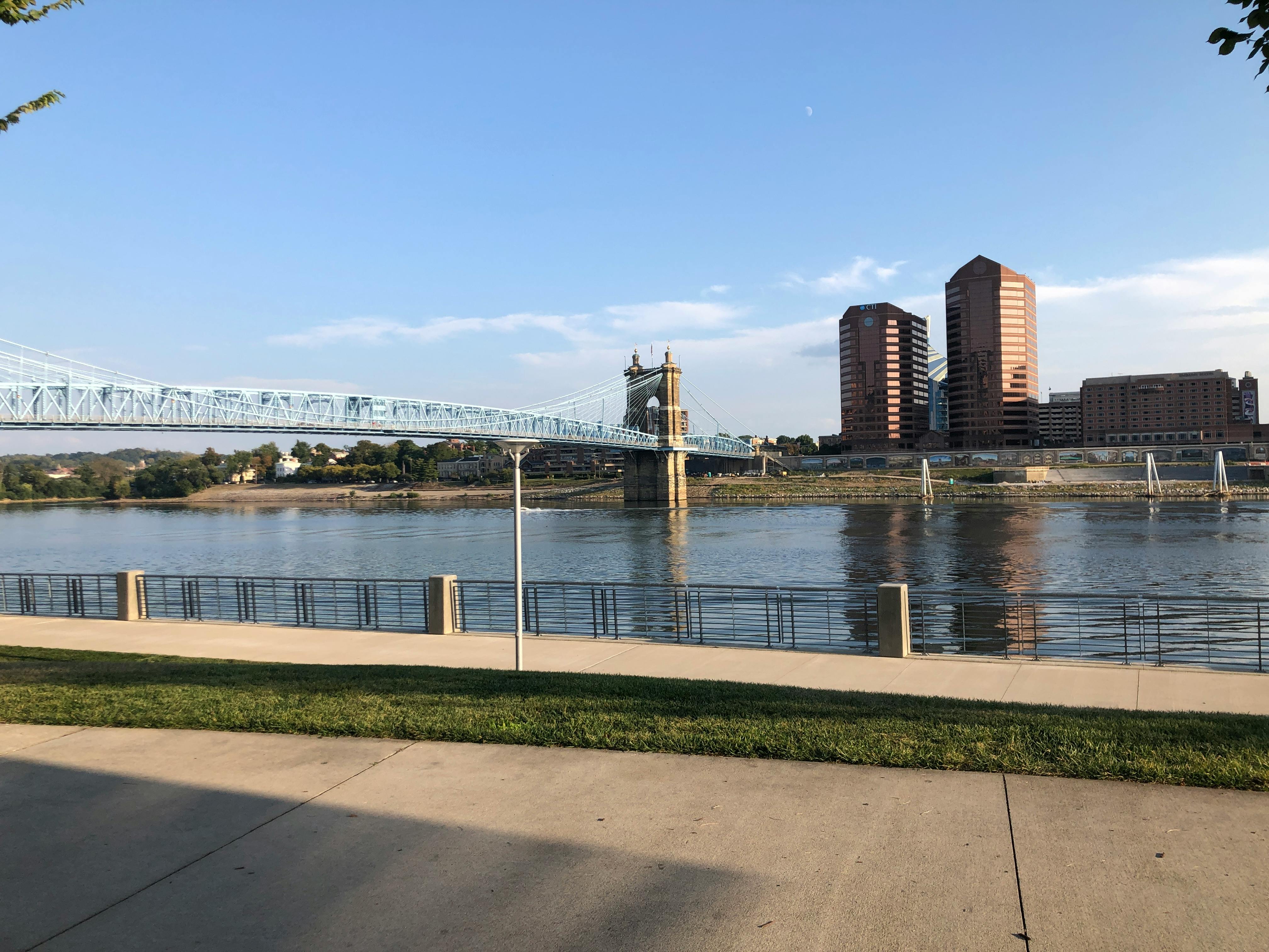 Serene view of Cincinnati's John A. Roebling Suspension Bridge over the Ohio River under clear skies.