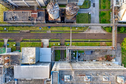 Aerial view of old factory with tanks and facility for industrial production located along road