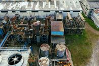 Drone view of industrial area with barrels for petroleum products and pipes connected with warehouses