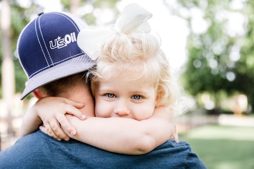 Free Little girl hugging father in park Stock Photo