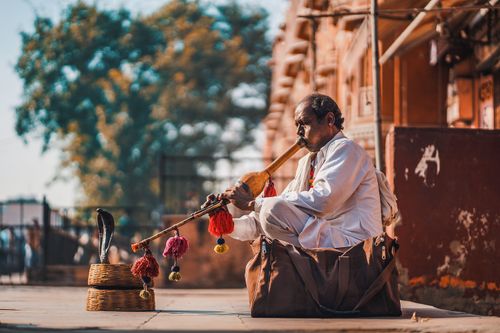 Free A snake charmer performing with a cobra on the streets of Jaipur, showcasing Indian culture and tradition. Stock Photo