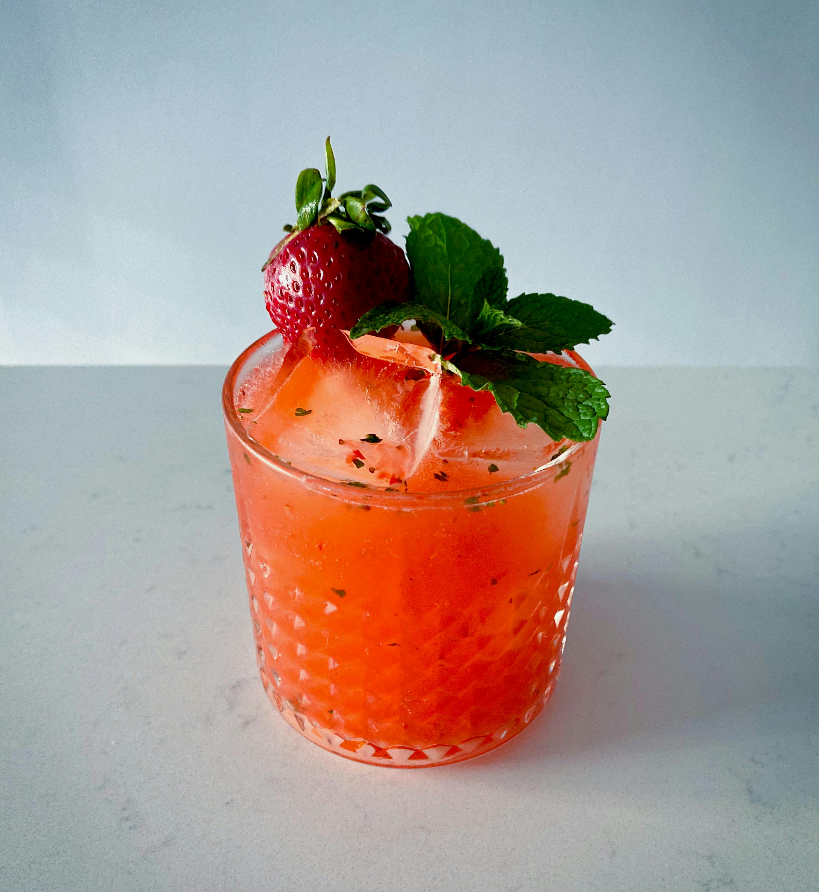 Free A vibrant strawberry mint cocktail in a crystal glass, perfect for summer refreshment. Stock Photo