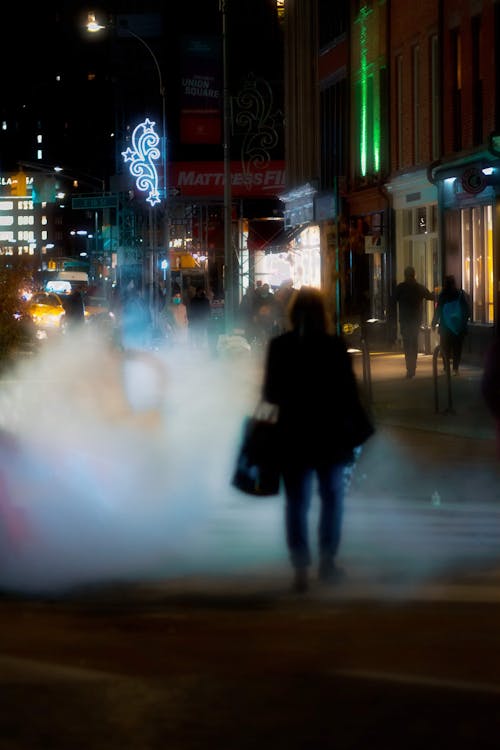 Anonymous people walking in street near buildings