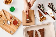 Top View of a Person Decorating a Triangle Shaped Cake