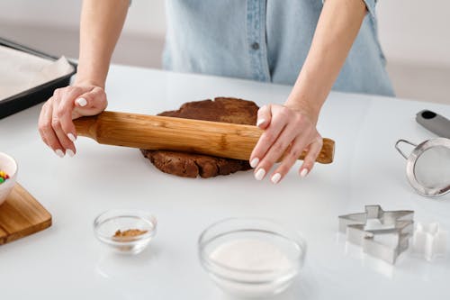 Free Person Flattening a Chocolate Dough With Rolling Pin Stock Photo