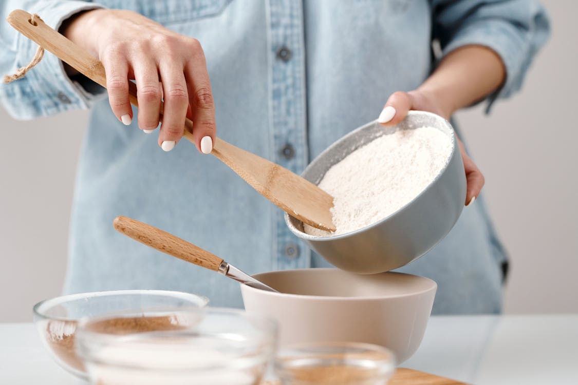 Free Person Adding Flour into a Bowl Stock Photo