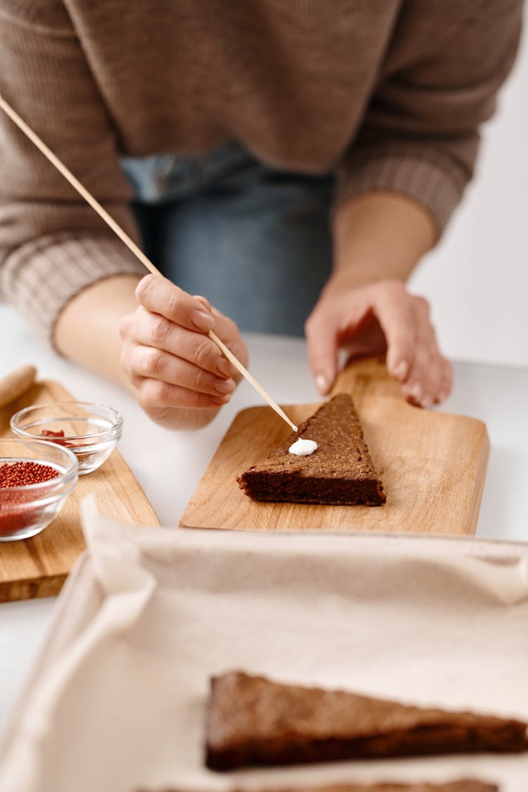 Person Decorating A Brown Cookie