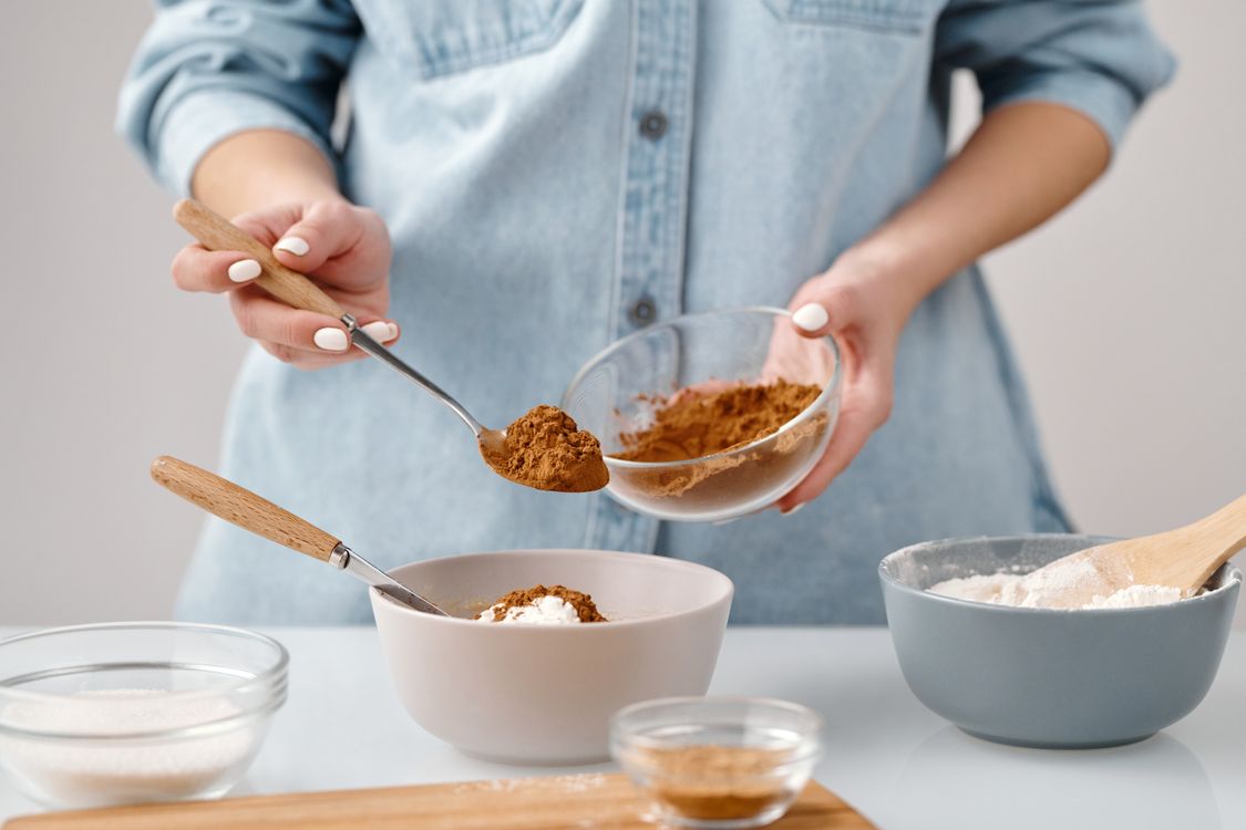 Person Adding a Spoon of Cinnamon in a Bowl · Free Stock Photo